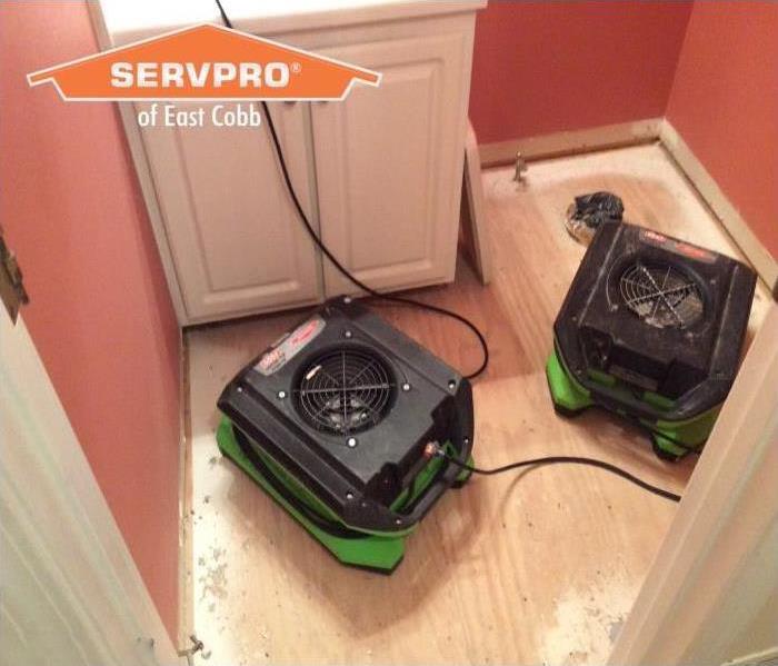 Water damage bathroom with drying equipment drying drywall, cabinets and subfloor