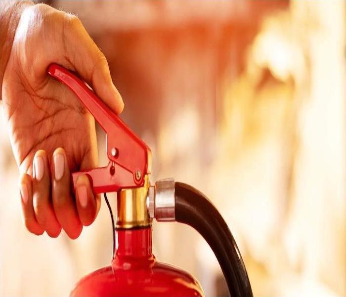 Hand holding activated fire extinguisher 