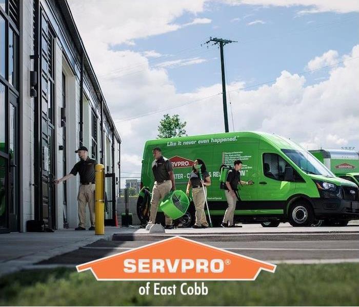 a group of employees with restoration tools walking away from SERVPRO van